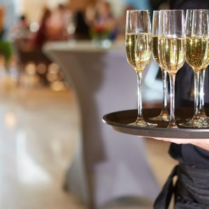 Waiter serving champagne glasses on a tray