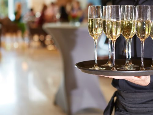 Waiter serving champagne glasses on a tray